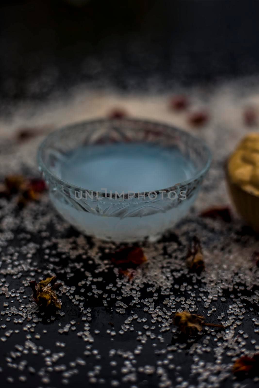 Ubtan/face mask/face pack of Multani mitti or fuller's earth on wooden surface in a glass bowl consisting of Multani mitti and coconut oil for the remedy or treatment of suntan.On the wooden surface.