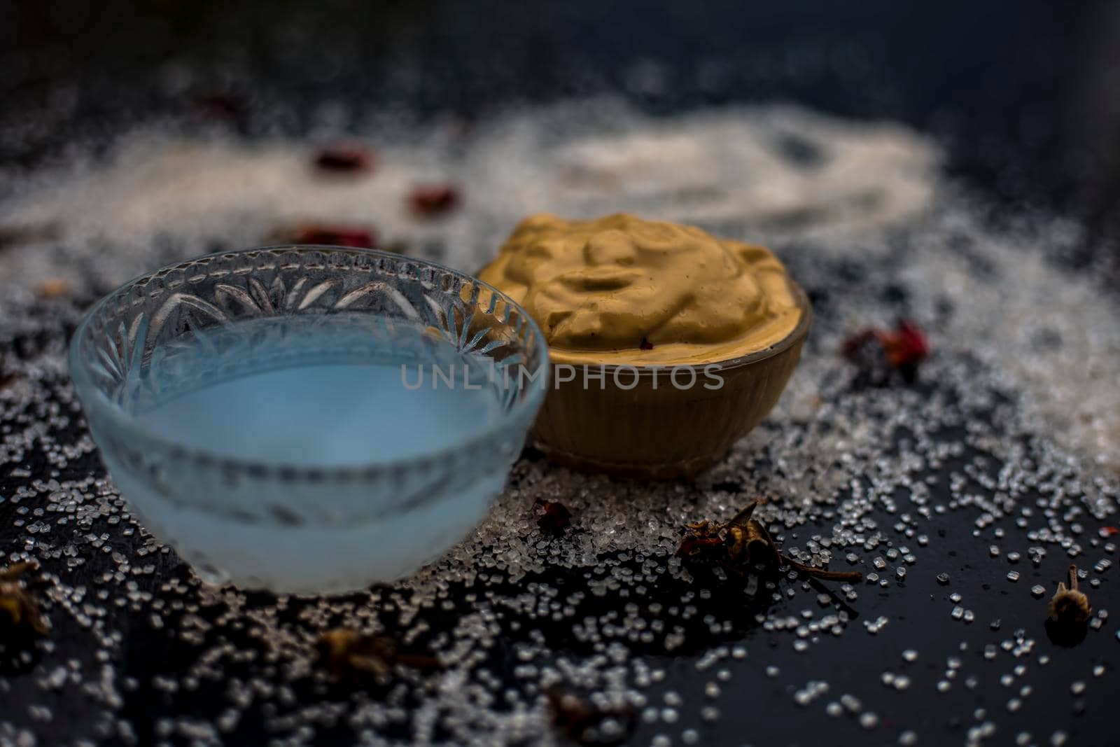 Ubtan/face mask/face pack of Multani mitti or fuller's earth on wooden surface in a glass bowl consisting of Multani mitti and coconut oil for the remedy or treatment of suntan.On the wooden surface.