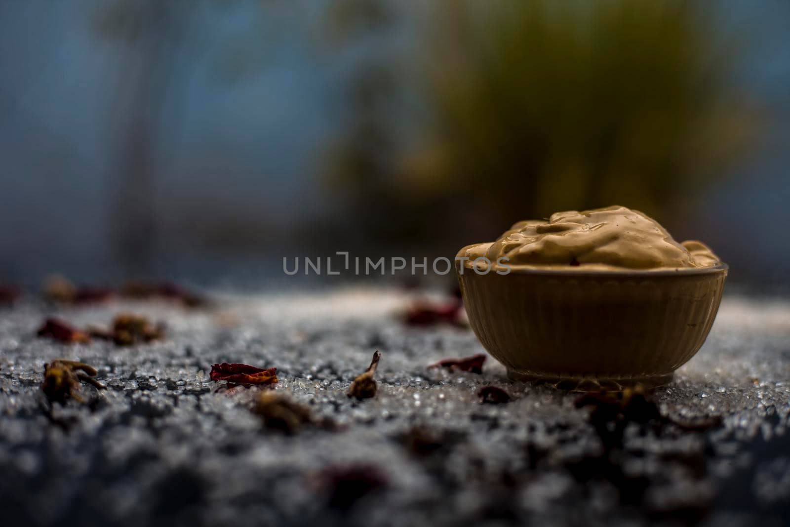 Ubtan/face mask/face pack of Multani mitti or fuller's earth on wooden surface in a glass bowl consisting of Multani mitti and coconut oil for the remedy or treatment of suntan.On the wooden surface. by mirzamlk