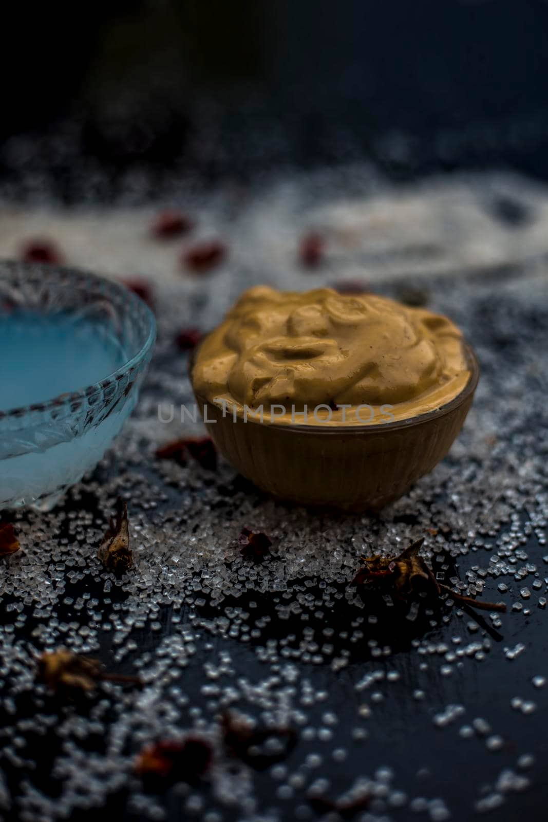 Ubtan/face mask/face pack of Multani mitti or fuller's earth on wooden surface in a glass bowl consisting of Multani mitti and coconut oil for the remedy or treatment of suntan.On the wooden surface.