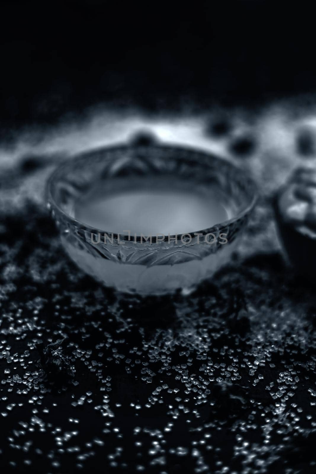 Ubtan/face mask/face pack of Multani mitti or fuller's earth on wooden surface in a glass bowl consisting of Multani mitti and coconut oil for the remedy or treatment of suntan.On the wooden surface.