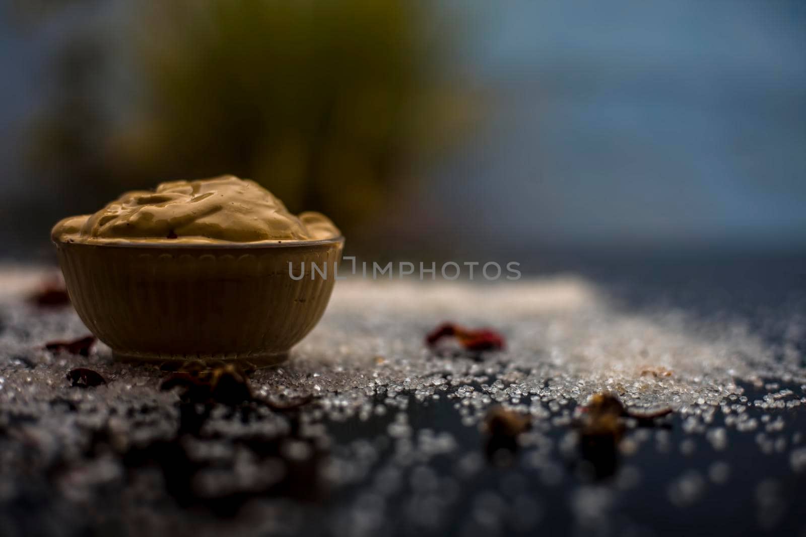 Ubtan/face mask/face pack of Multani mitti or fuller's earth on wooden surface in a glass bowl consisting of Multani mitti and coconut oil for the remedy or treatment of suntan.On the wooden surface. by mirzamlk