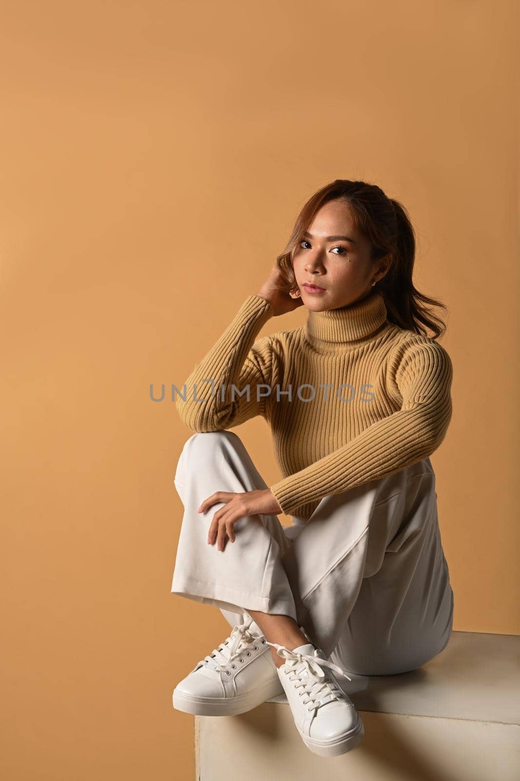 Portrait of tendy woman in autumn outfit posing on beige background. Fashion studio photo, Autumn and Winter concept by prathanchorruangsak