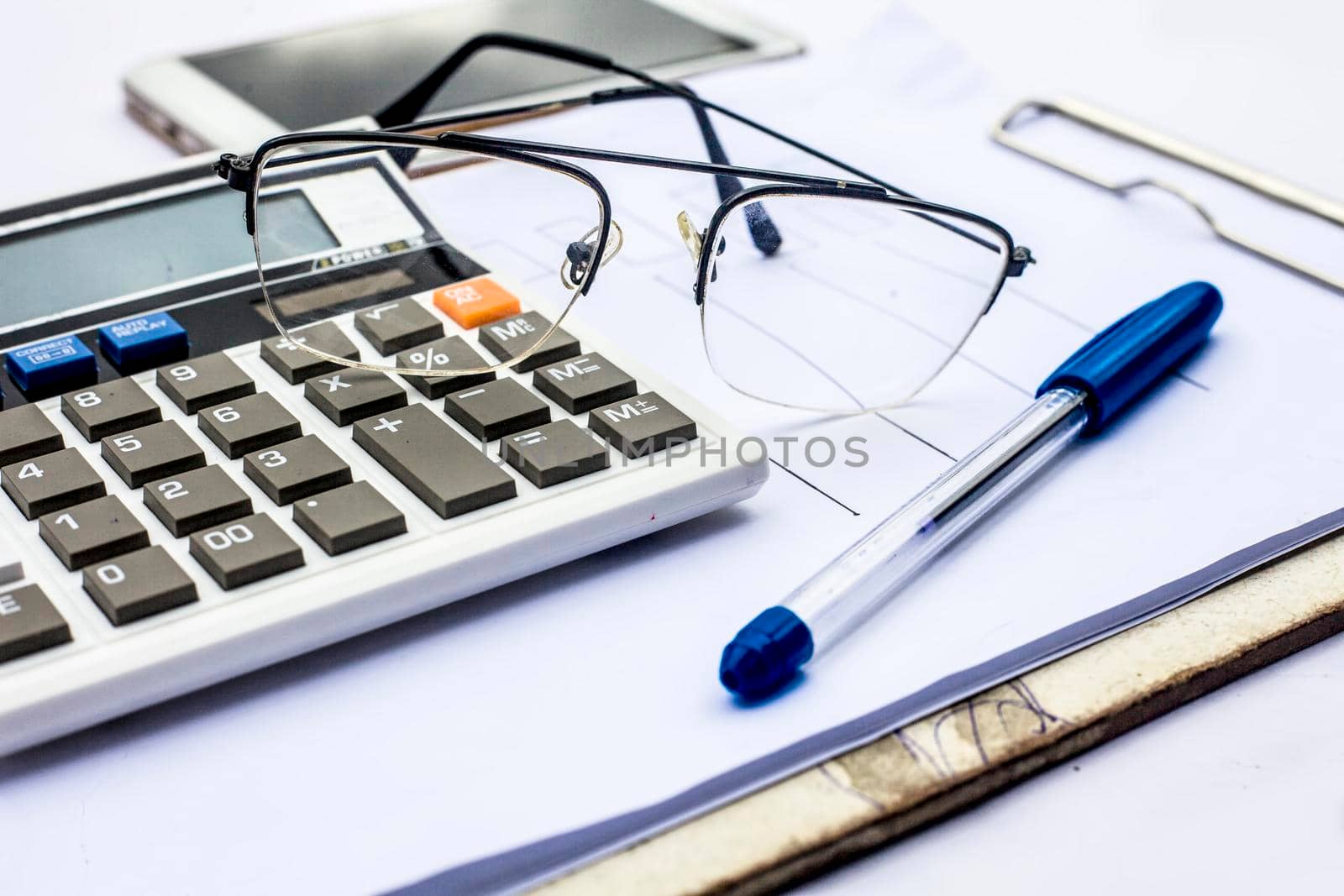 Close up of workplace of businessman or finance consultant isolated on white using credit card, cell phone, pen and calculator like things.