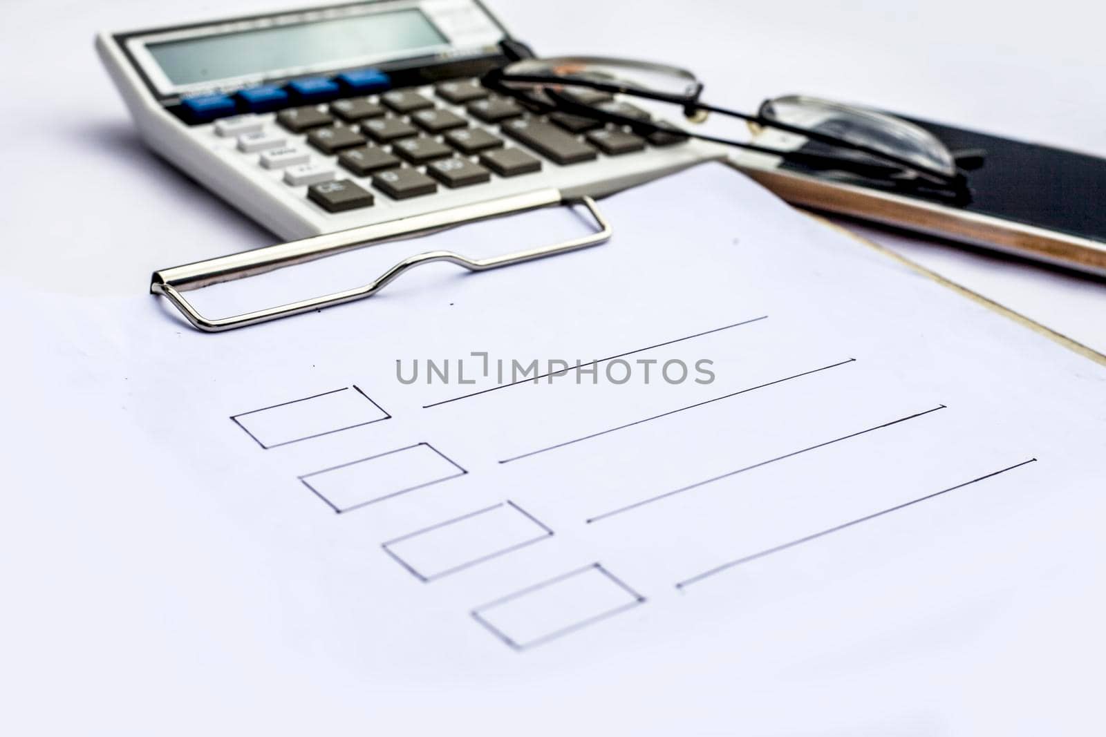 Close up of workplace of businessman or finance consultant isolated on white using credit card, cell phone, pen and calculator like things and some coins also.
