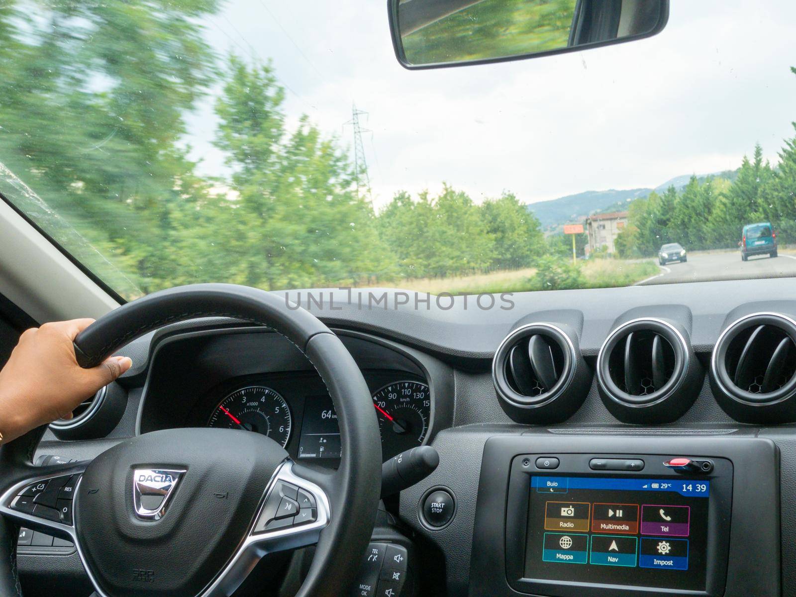 Beautiful business lady driving her car a cloudy day in summertime