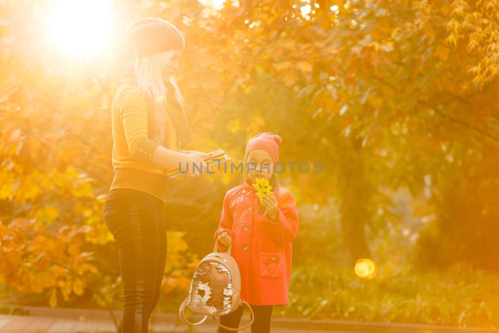 portrait of a young woman and her daughter in the autumn park by Andelov13