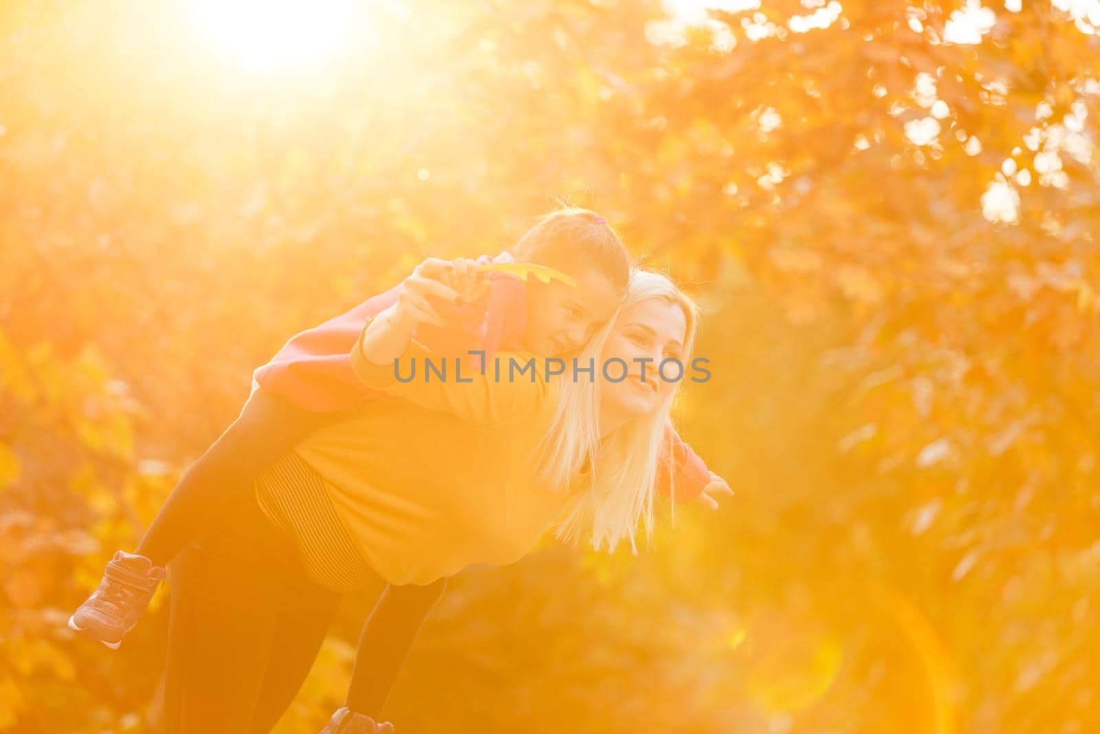 portrait of a young woman and her daughter in the autumn park