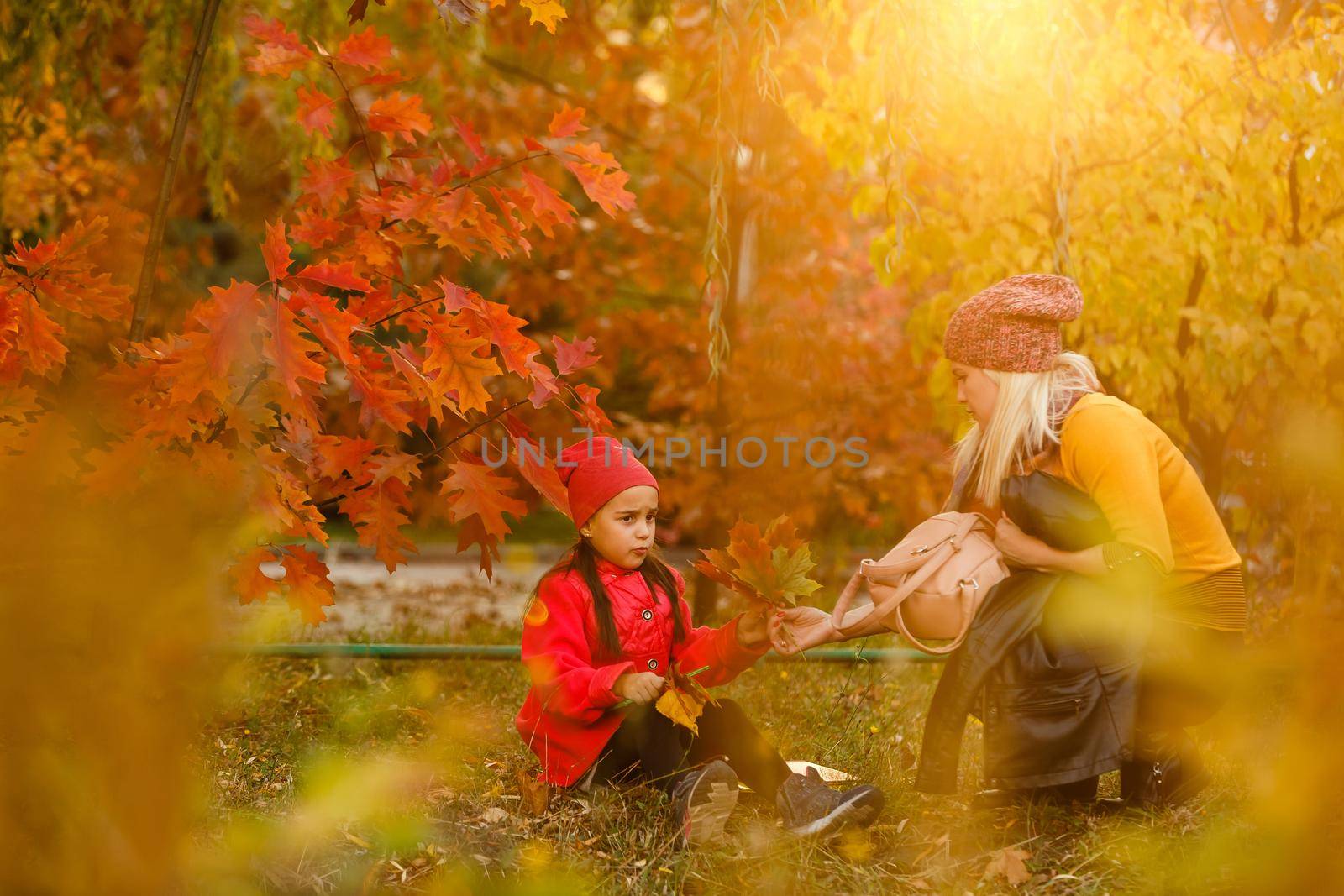 Mom leads her daughter to school. Return to school. Woman and girl with backpack behind the back. Beginning of lessons. First day of fall.