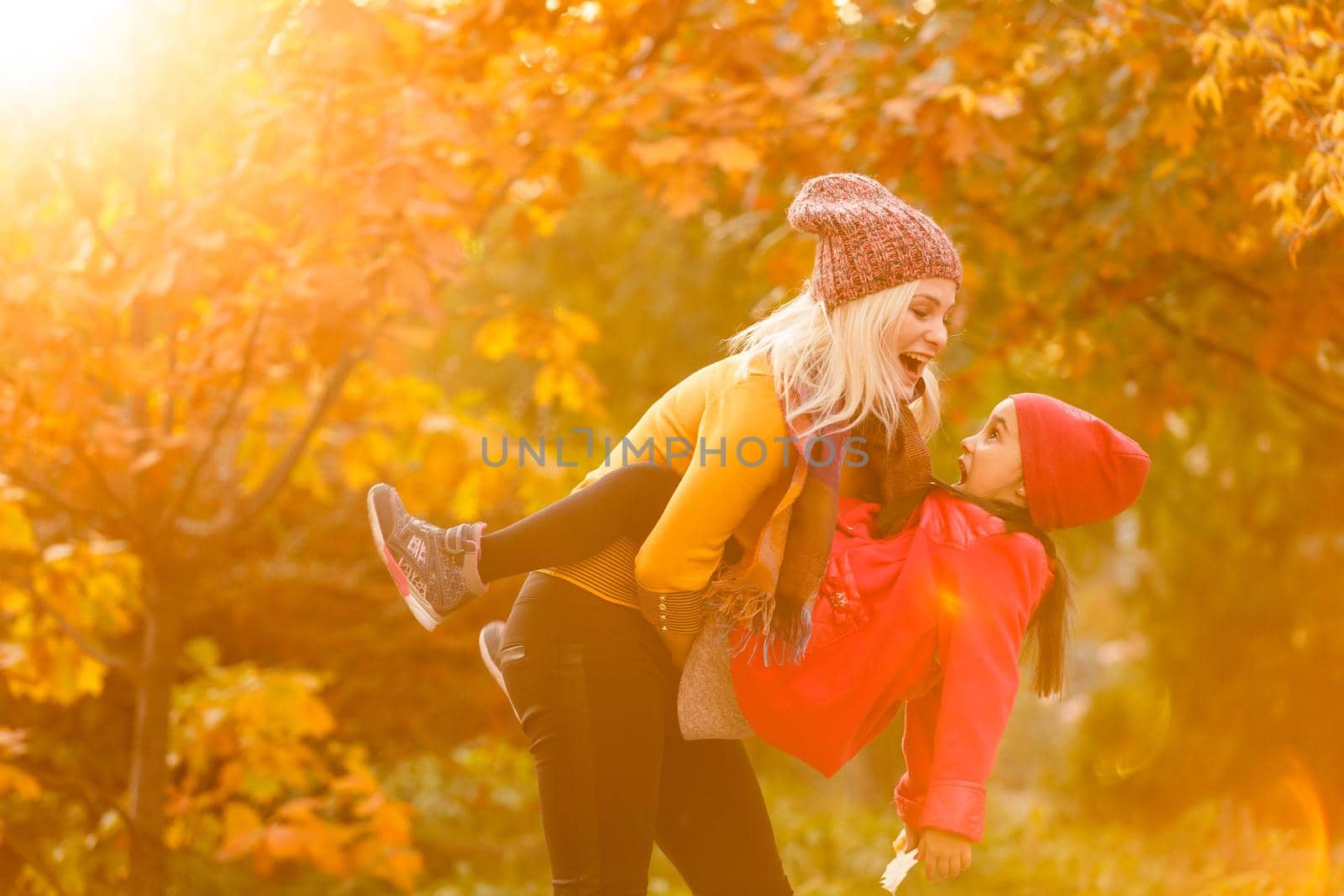 portrait of a young woman and her daughter in the autumn park