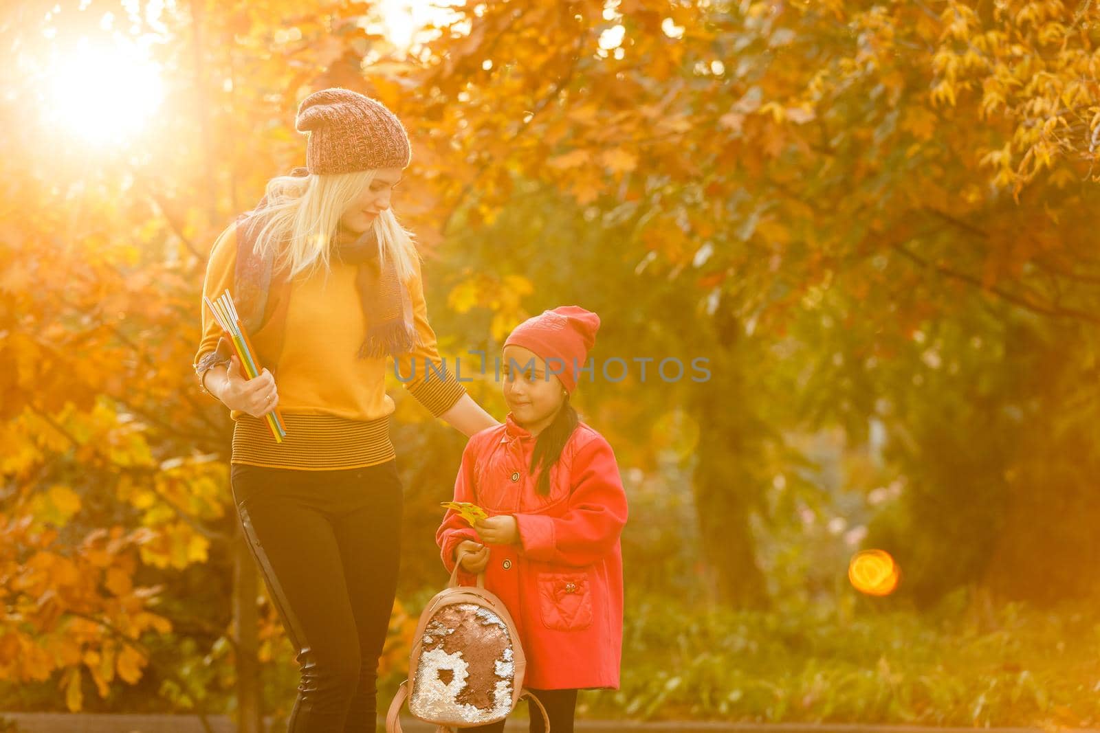 portrait of a young woman and her daughter in the autumn park by Andelov13