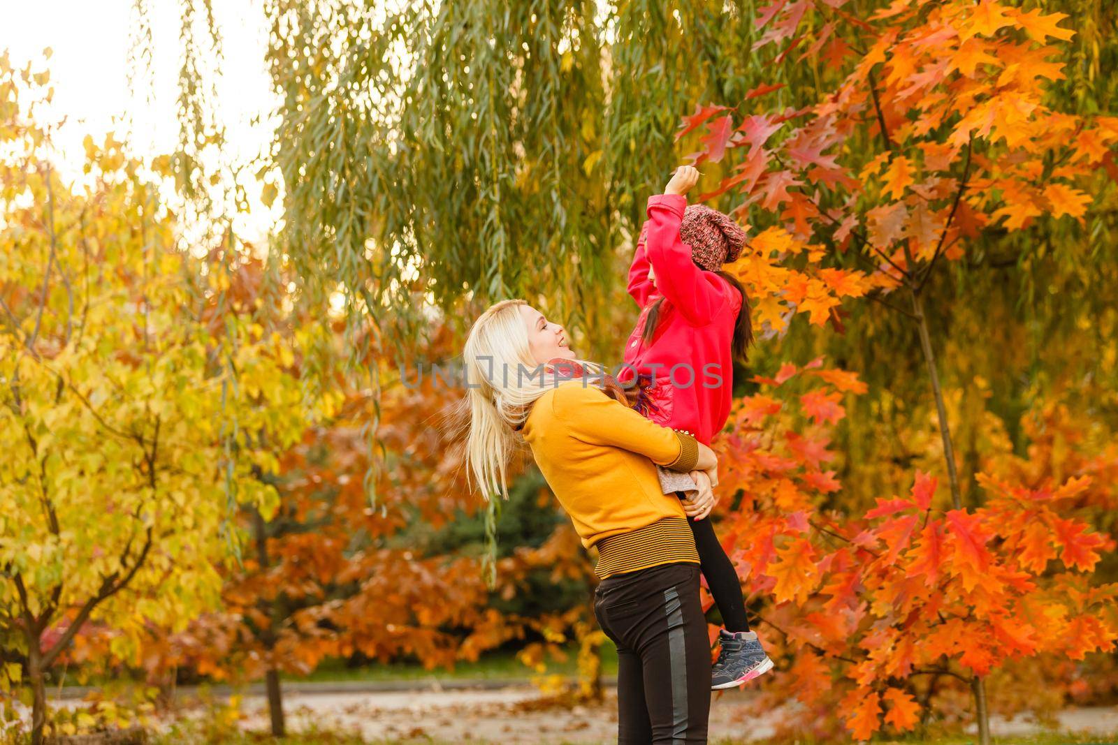 mother and her toddler girl have fun autumn by Andelov13