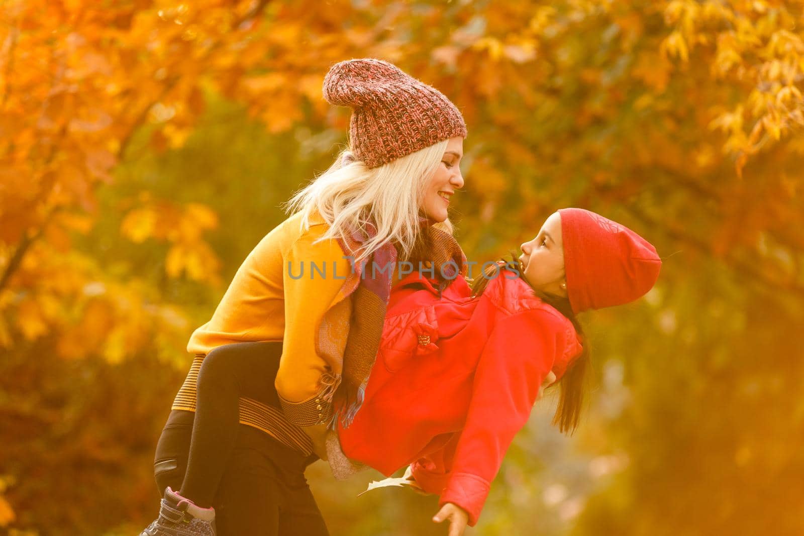 portrait of a young woman and her daughter in the autumn park