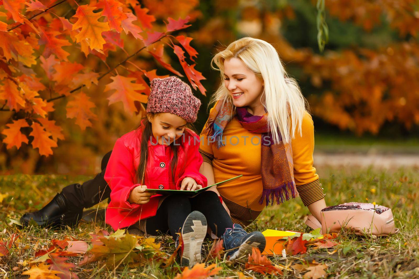 mother and her toddler girl have fun autumn