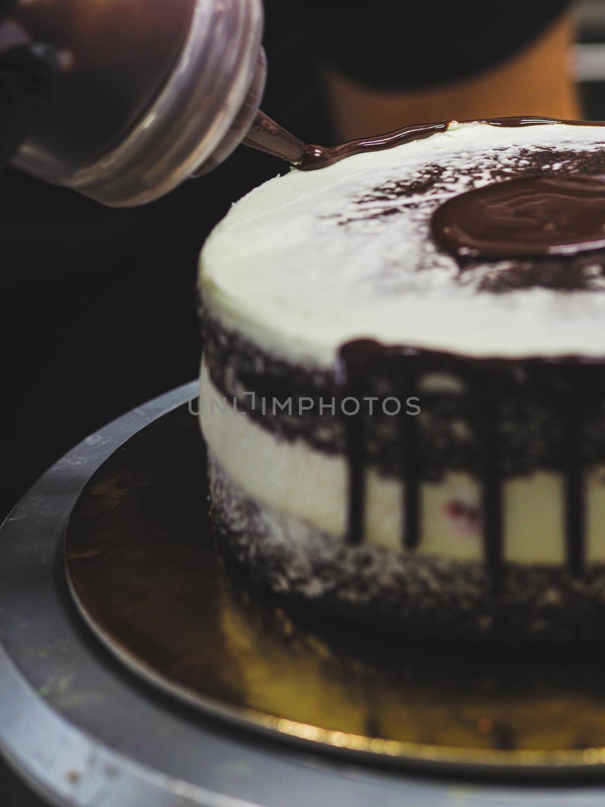 decorating a frosted cake with chocolate and nutella