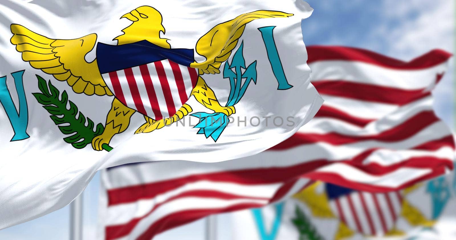 Flags of United States Virgin Islands waving in the wind with the US flag on a clear day by rarrarorro