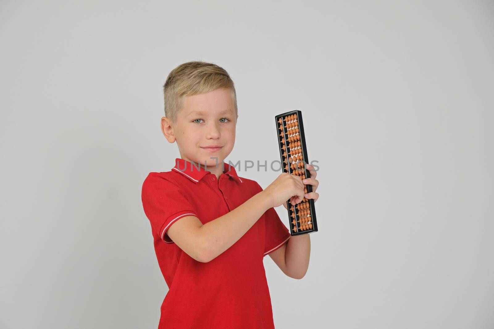 Little boy doing simple math exercises with abacus scores. Mental arithmeric.