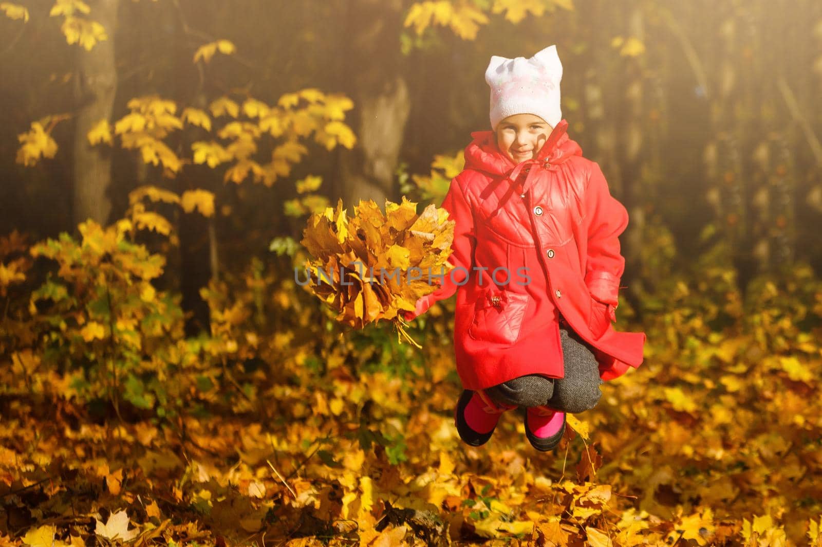 Young daughter playing in autumn park