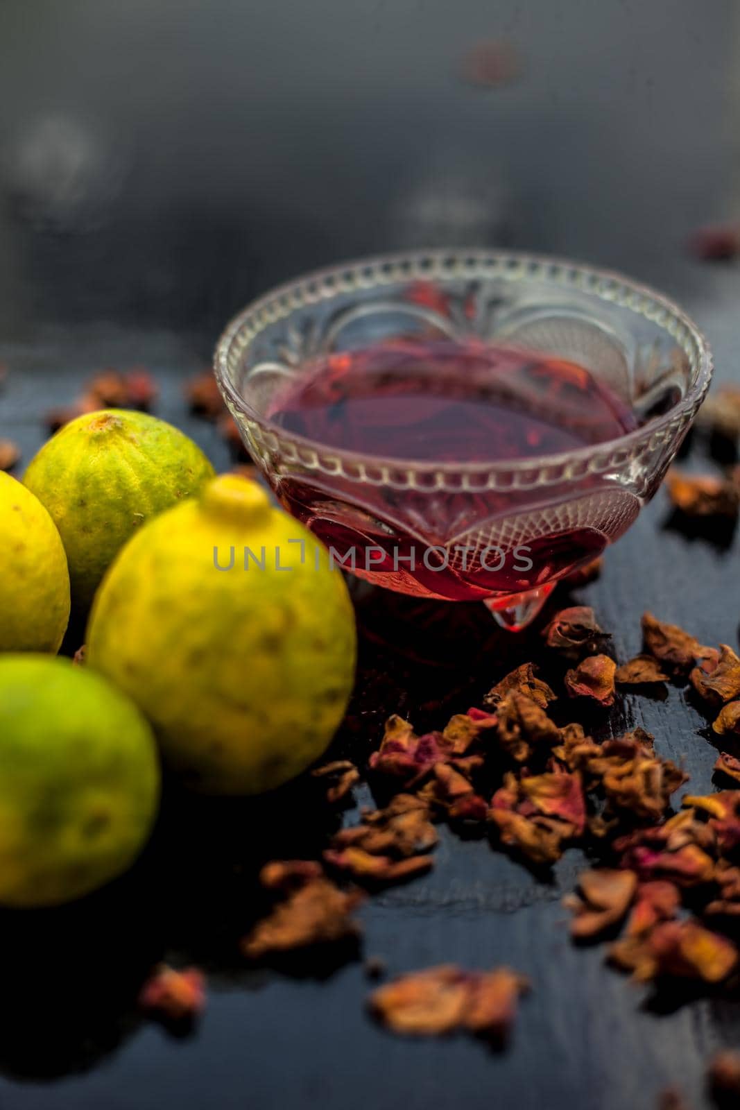 Face mask or pack on wooden surface consisting of rose water, lemon juice for acne and pimple. Vertical shot. by mirzamlk