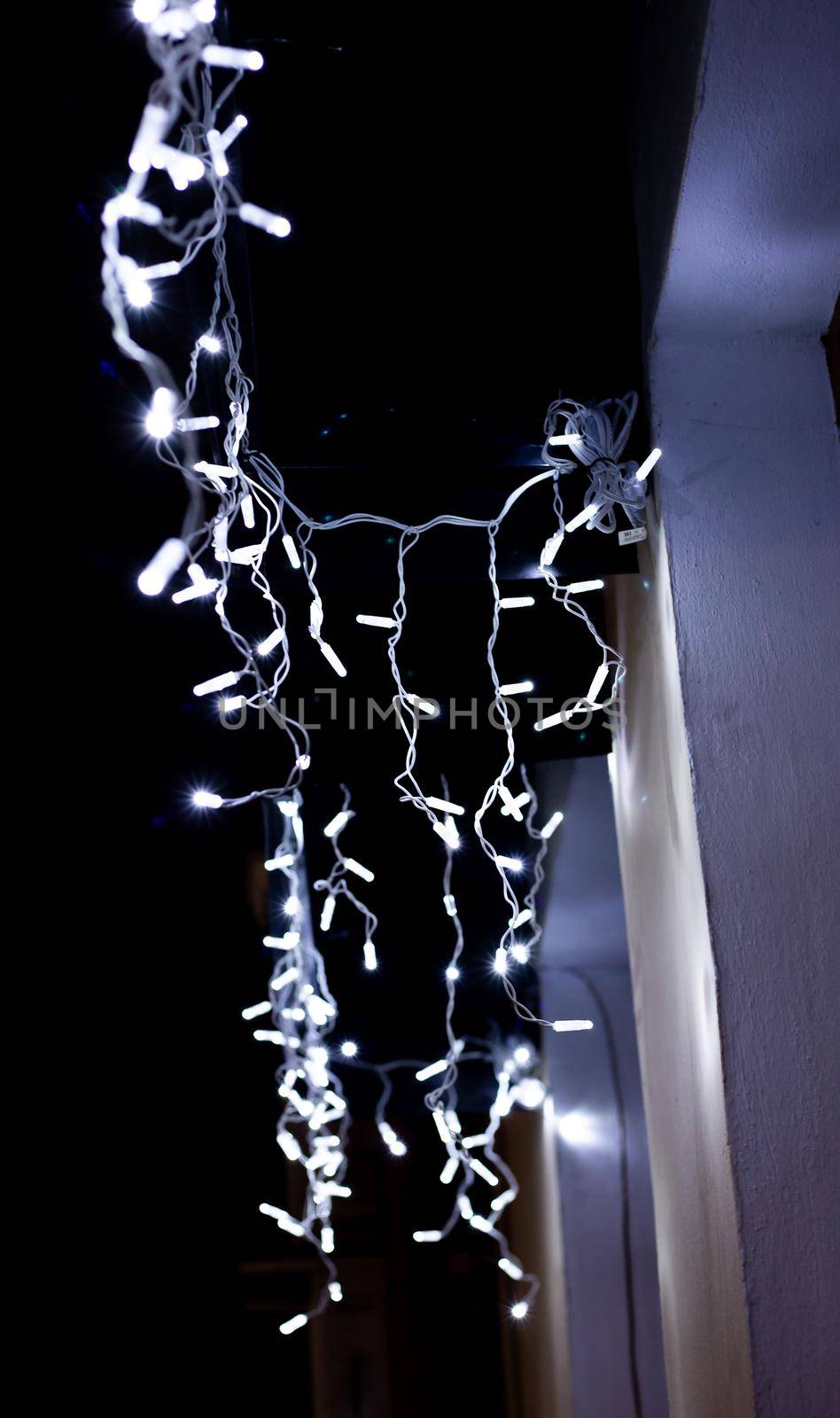 White garlands hang on the wall of the building at night. Modern classical style