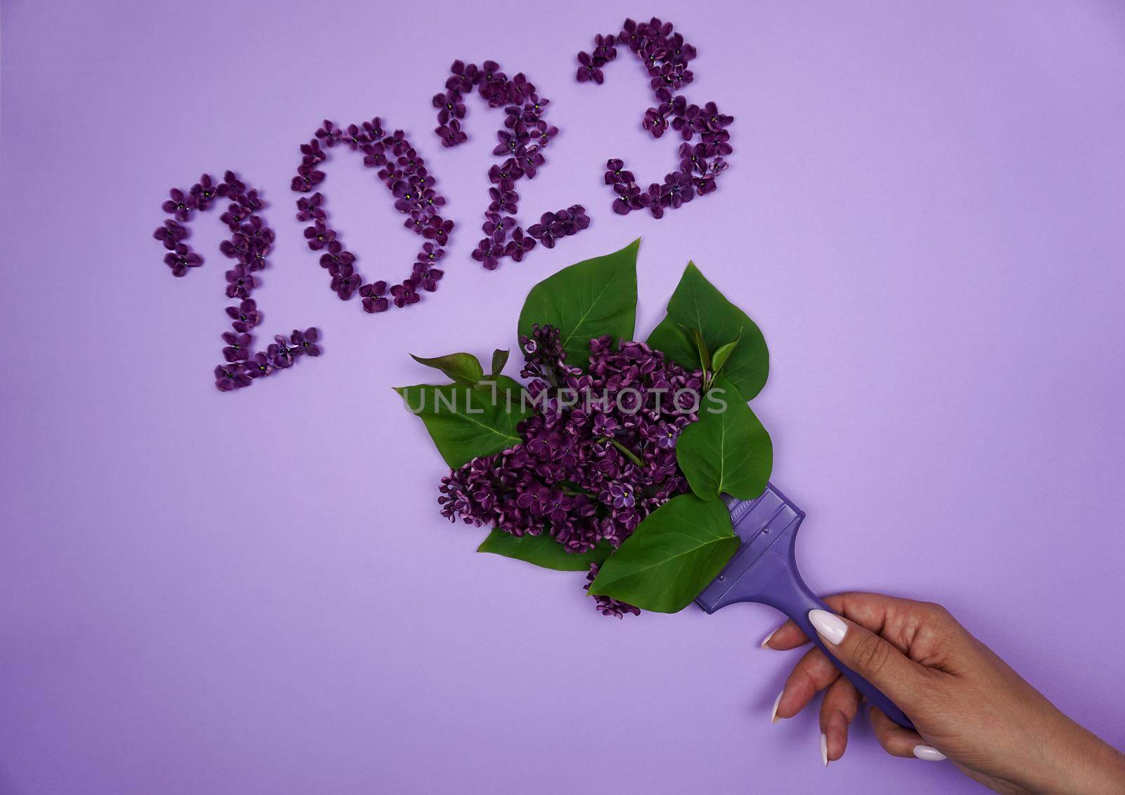 The inscription 2023 is laid out on a lilac background of lilac flowers by Spirina