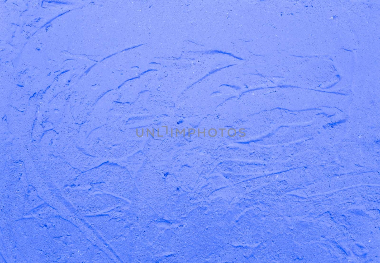 Blue abstract background..Beautiful blue textured plaster on the wall..Background from blue stucco..Streaks of paint on the wall.