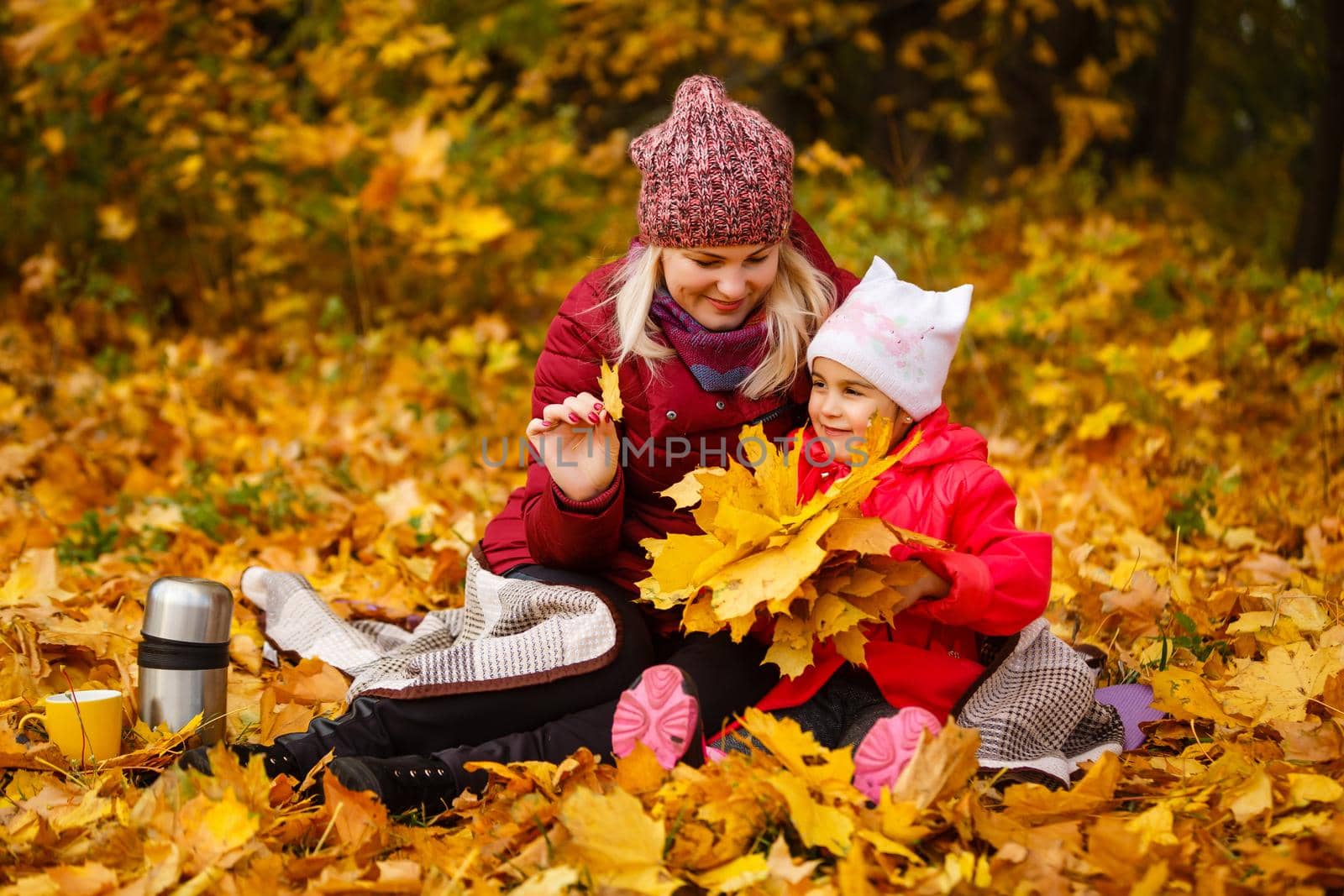 Mother daughter time. Soft focus shot of a mother and daughter reading a book together relaxing near the autumn park