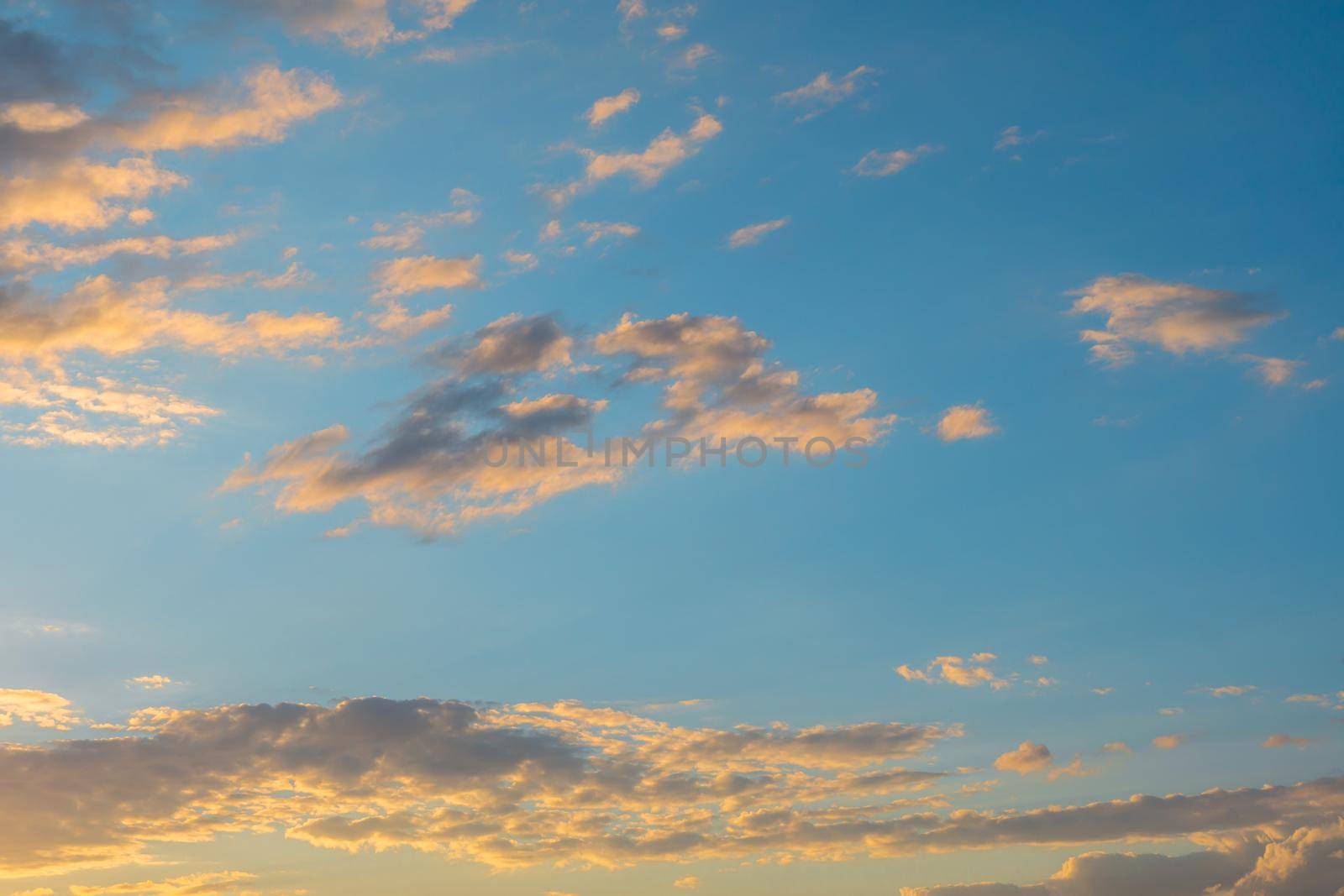 Beautiful sunset sky with colorful clouds on a blue background