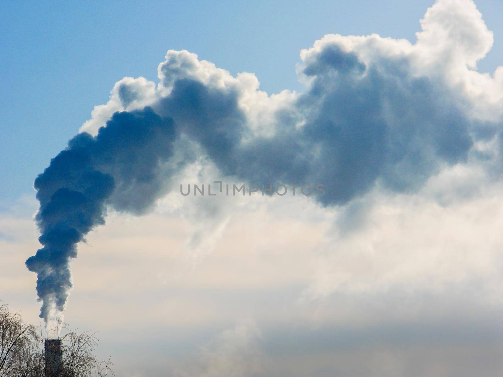 industrial chimneys with heavy smoke causing air pollution on gray sky background. Chimney white smoke on a blue sky.