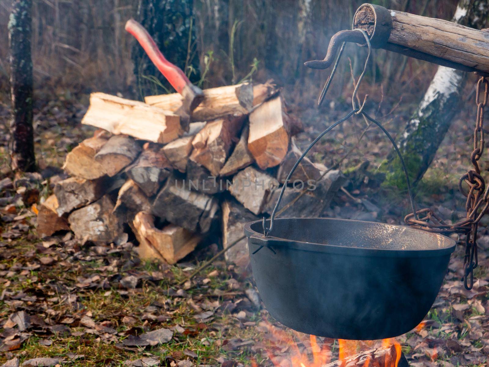 Cooking delicious tasty food outdoors on fire in iron pot by gelog67