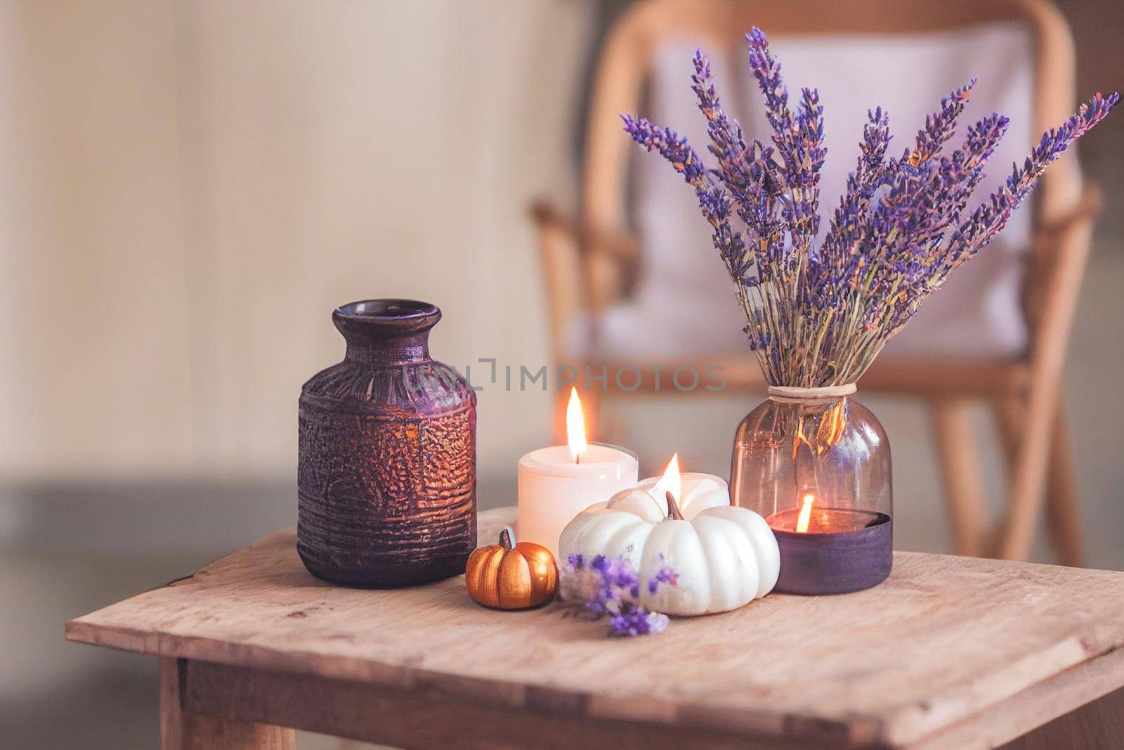 Autumn hygge home decor arrangement, concept of hygge and coziness, burning white fragrance candle by FokasuArt