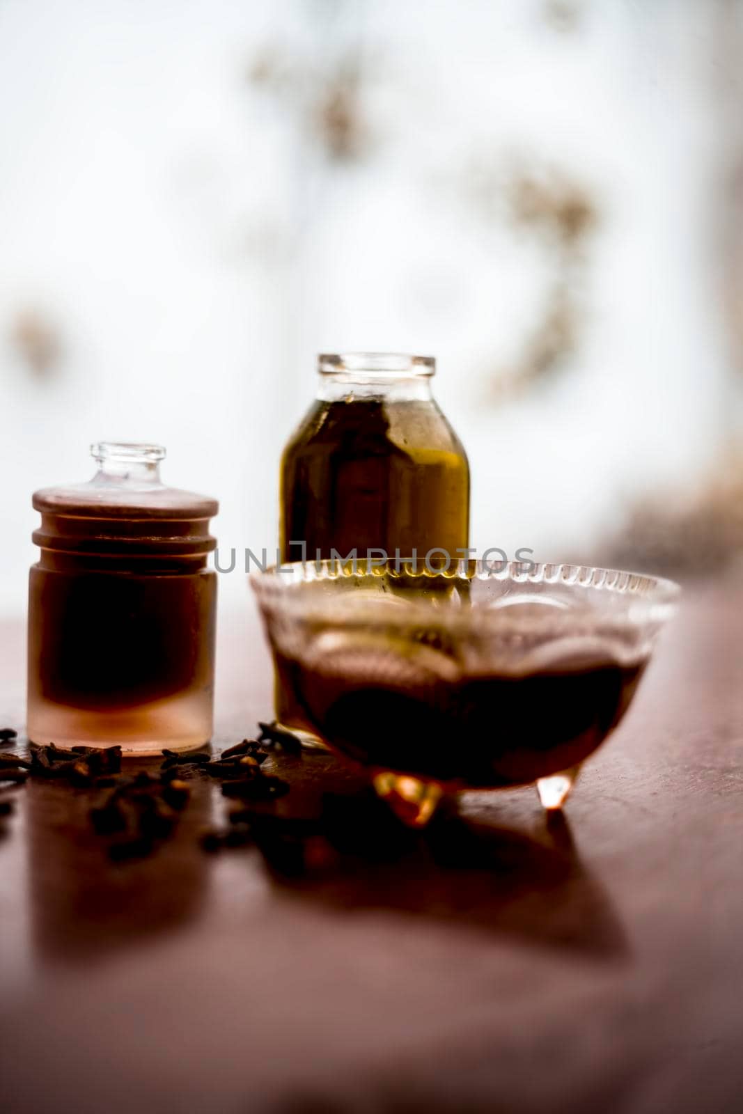 Face mask of clove oil on wooden surface consisting of clove oil and olive oil for the treatment of cleaning dirt and black heads from the skin.