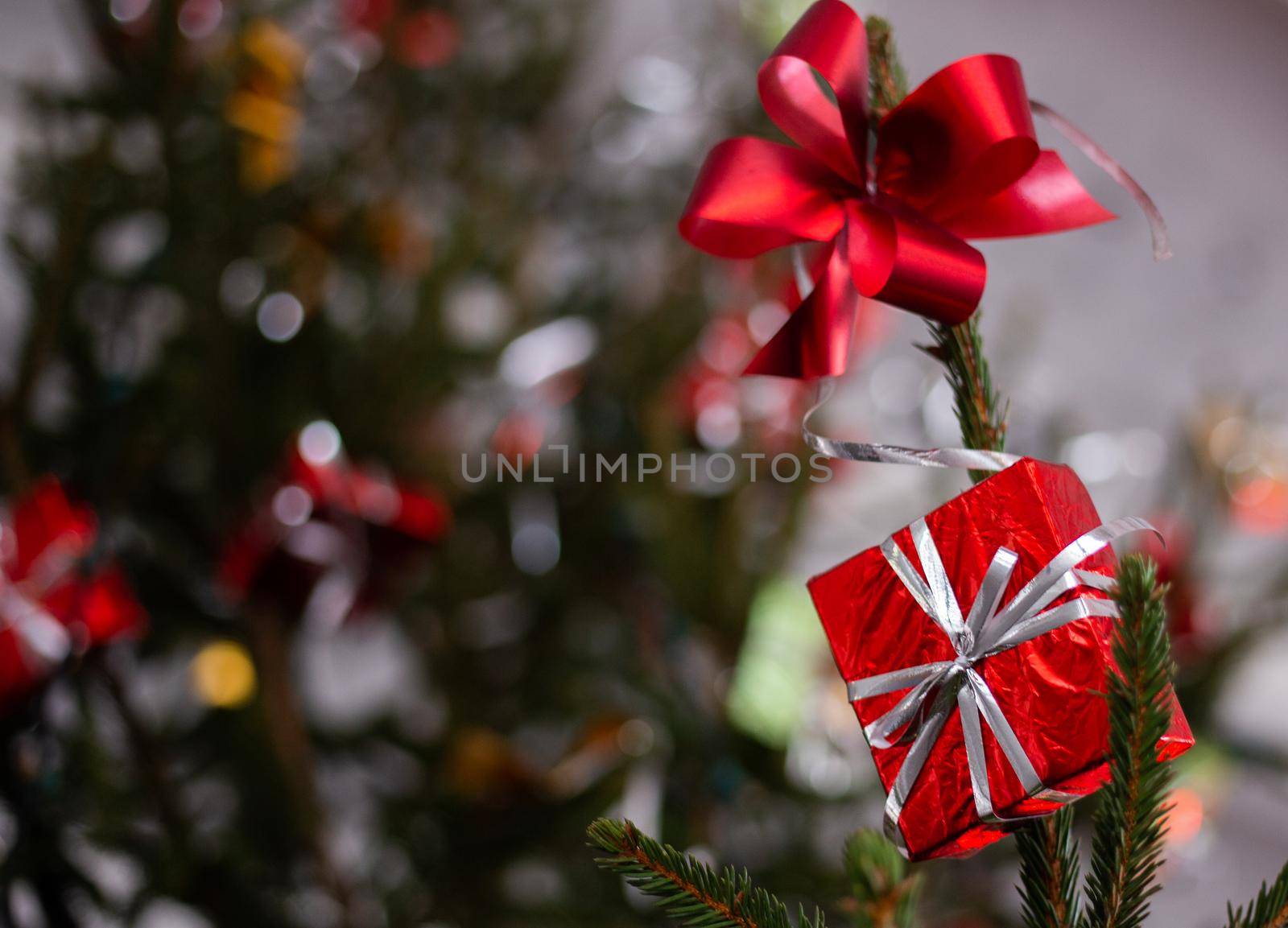 Red gift box hanging on christmas tree. Christmas presents and decorations on the Christmas tree.