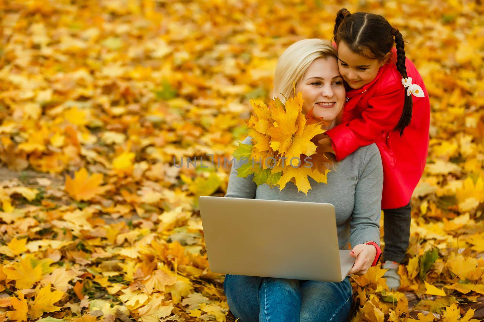 Urban woman and daughter with laptop in park. slim hipster woman in jeans using notebook. freelancer using communication technology remote work and eco-friendly lifestyle.