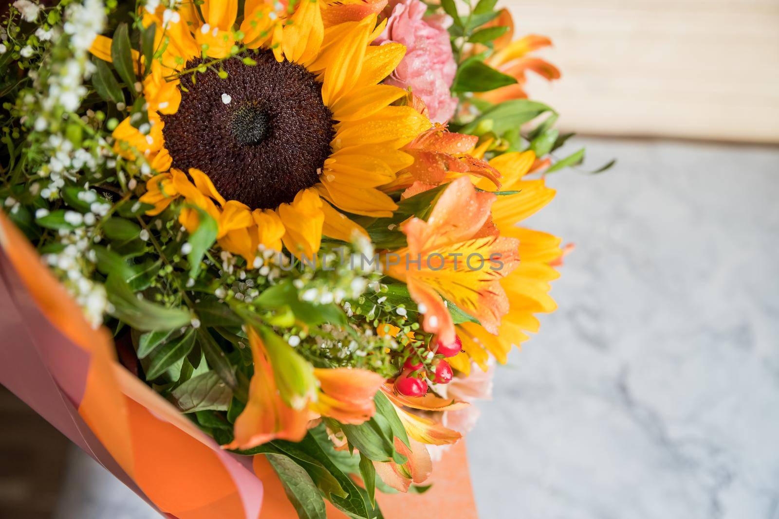 Hello August. Beautiful autumn bouquet with sunflowers and heart card close up on abstract light grey background.