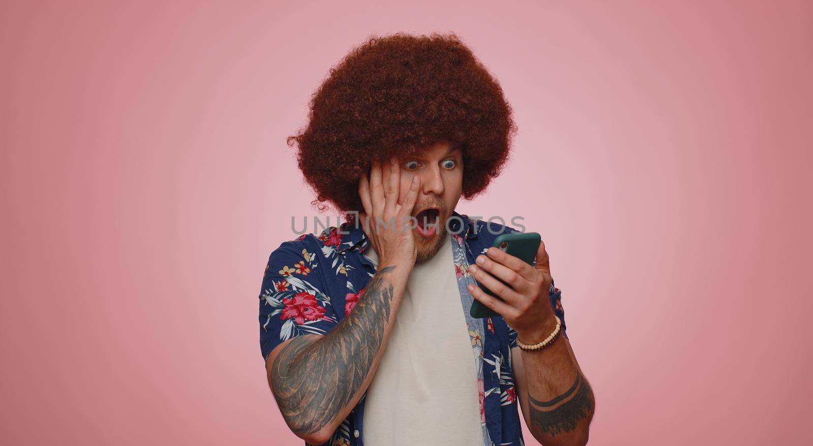 Happy excited joyful man in casual shirt use mobile cell phone typing browsing shouting say wow yes found out great big win, good news, lottery goal achievemen, celebrating success, winning