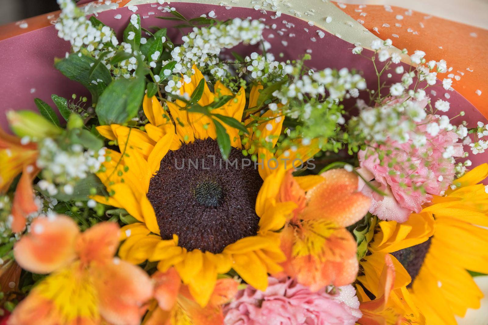 Hello August. Beautiful autumn bouquet with sunflowers and heart card close up on abstract light grey background.