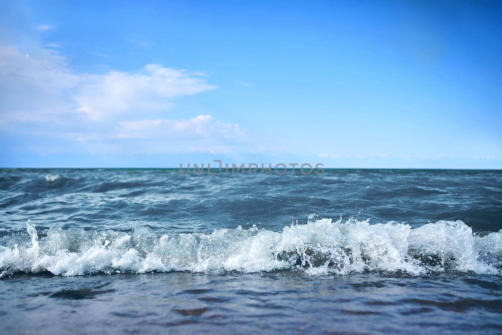 Beach with waves from the sea. Blue water in the beautiful ocean.