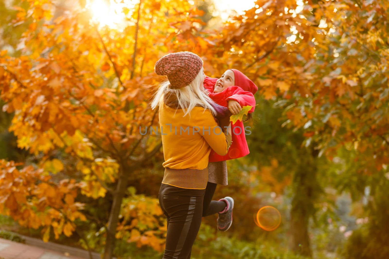 portrait of a young woman and her daughter in the autumn park by Andelov13