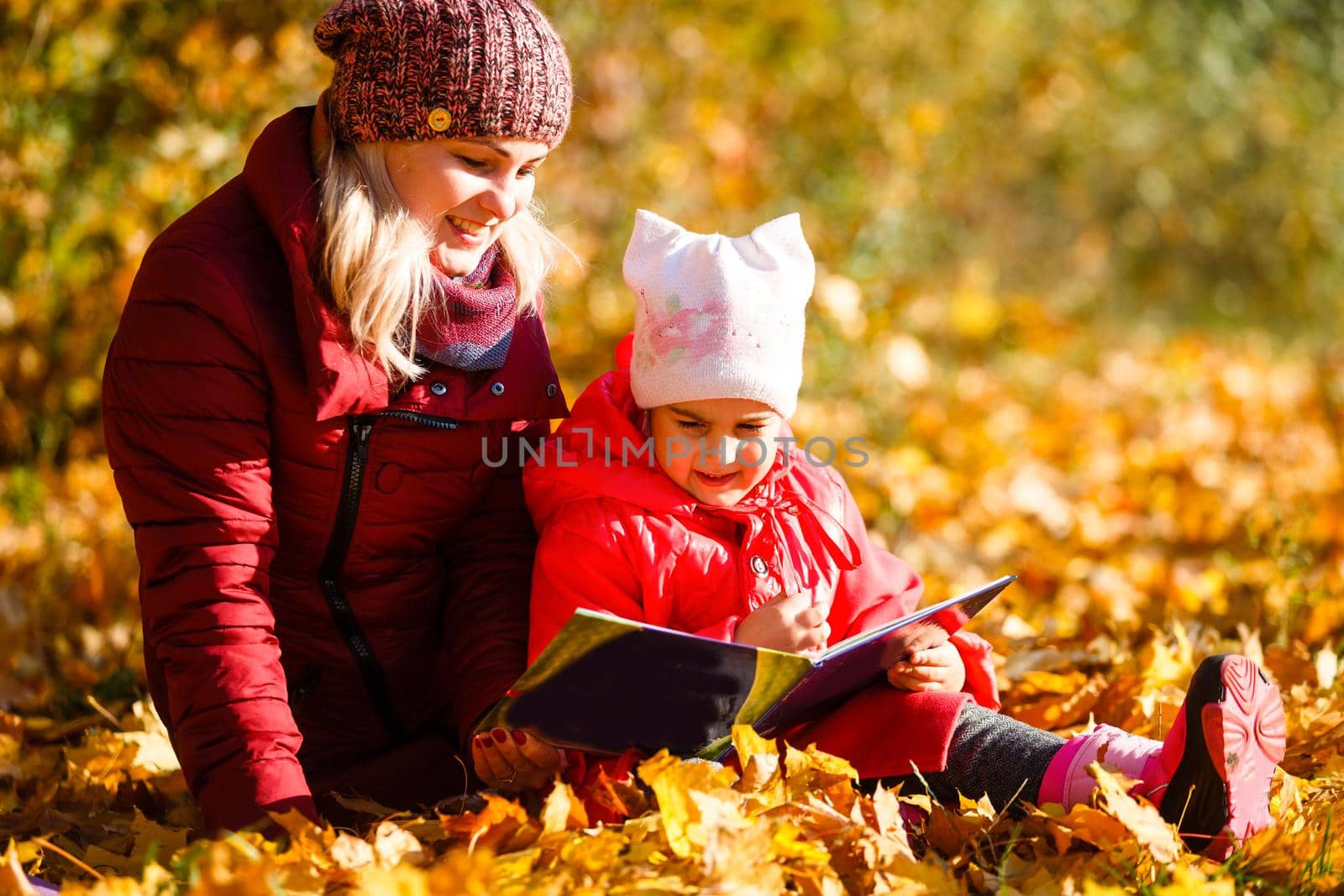 Mother daughter time. Soft focus shot of a mother and daughter reading a book together relaxing near the autumn park
