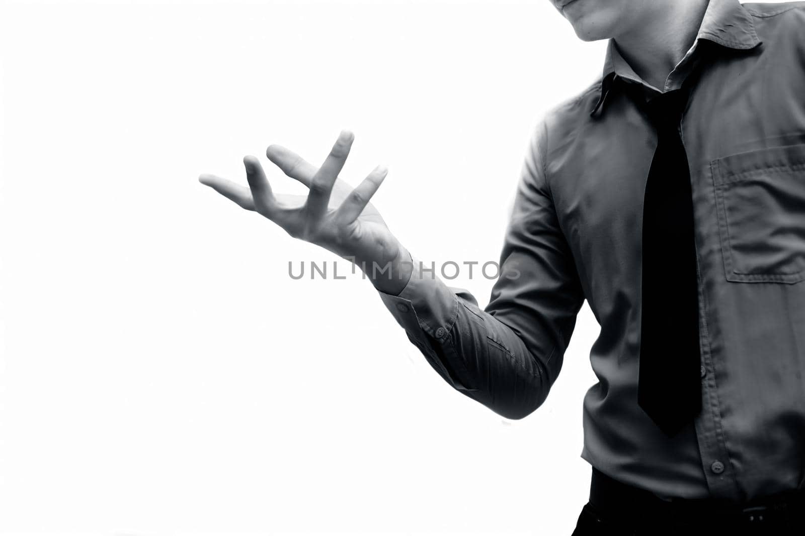 A too-young businessman wearing a blue colored shirt and a black tie isolated on white and Trying to expresses his doubtfulness by some hand gesture. Isolated on white.