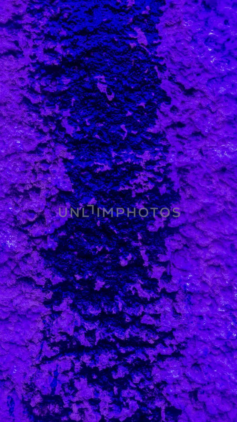 Purple flowed paint on a rough wall.