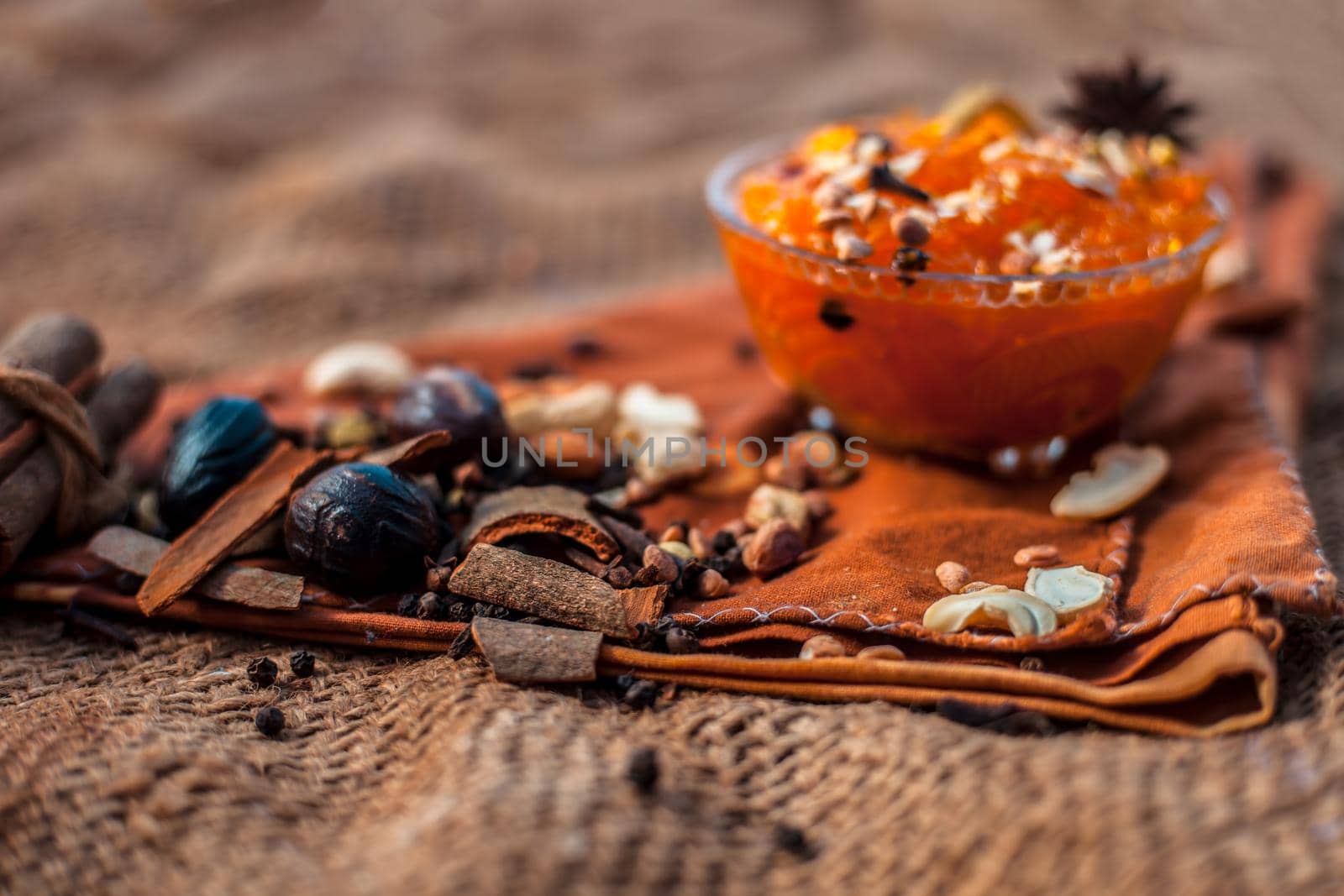 Famous mango preservation i.e. Murba or Murabba in a glass bowl on jute bags surface along with dry fruits and spices with it.Horizontal shot with background blurred. by mirzamlk