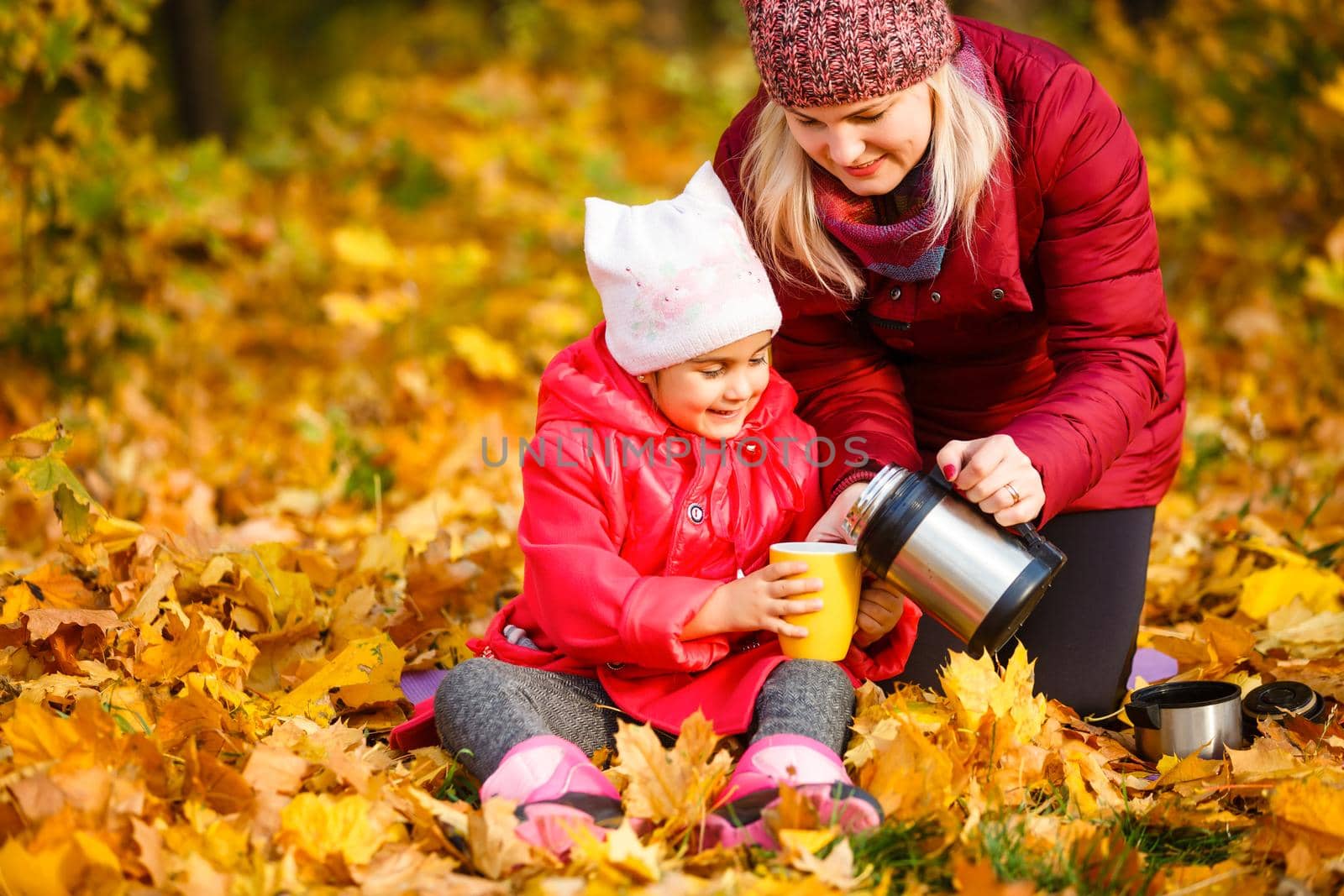Mother daughter time. Soft focus shot of a mother and daughter reading a book together relaxing near the autumn park