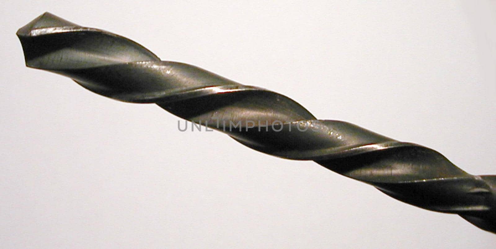 Close Up Detail of Metal Drill Bit Angled Across White Background in Panoramic Format