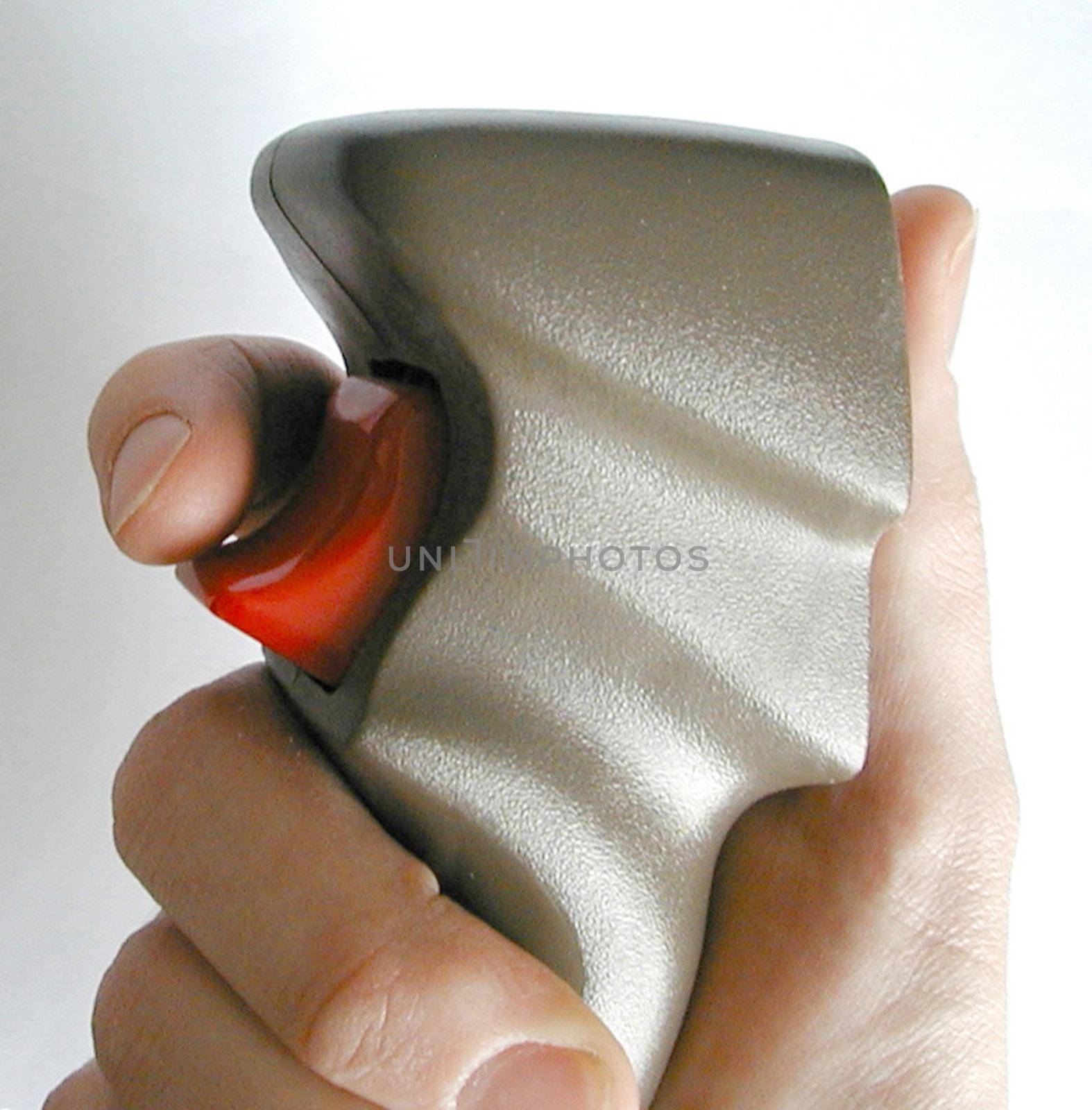 Man holding a computer joystick with his finger poised over the red control button, close up side view