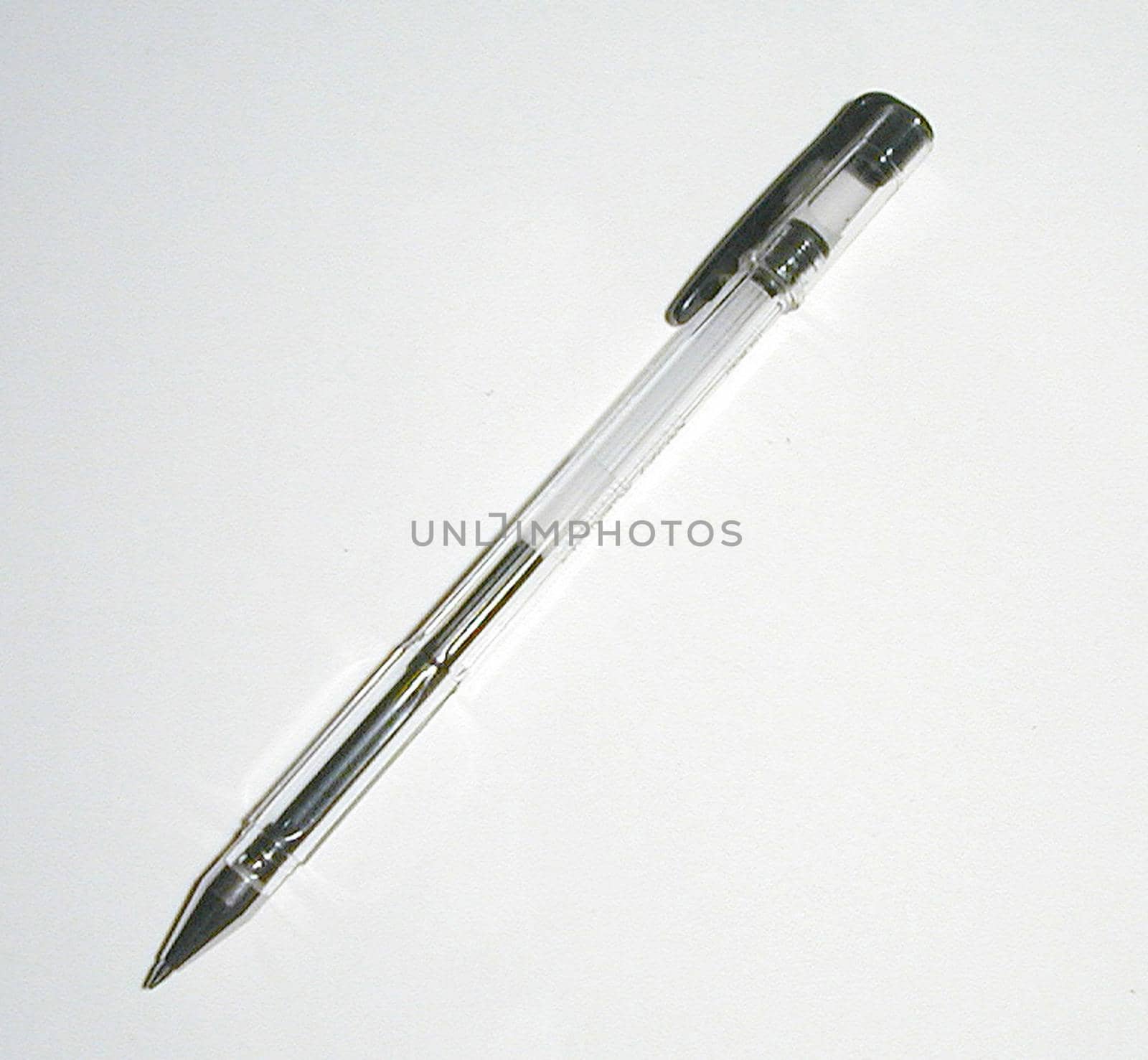 Black ball point pen or roller ball lying diagonally on white with copy space