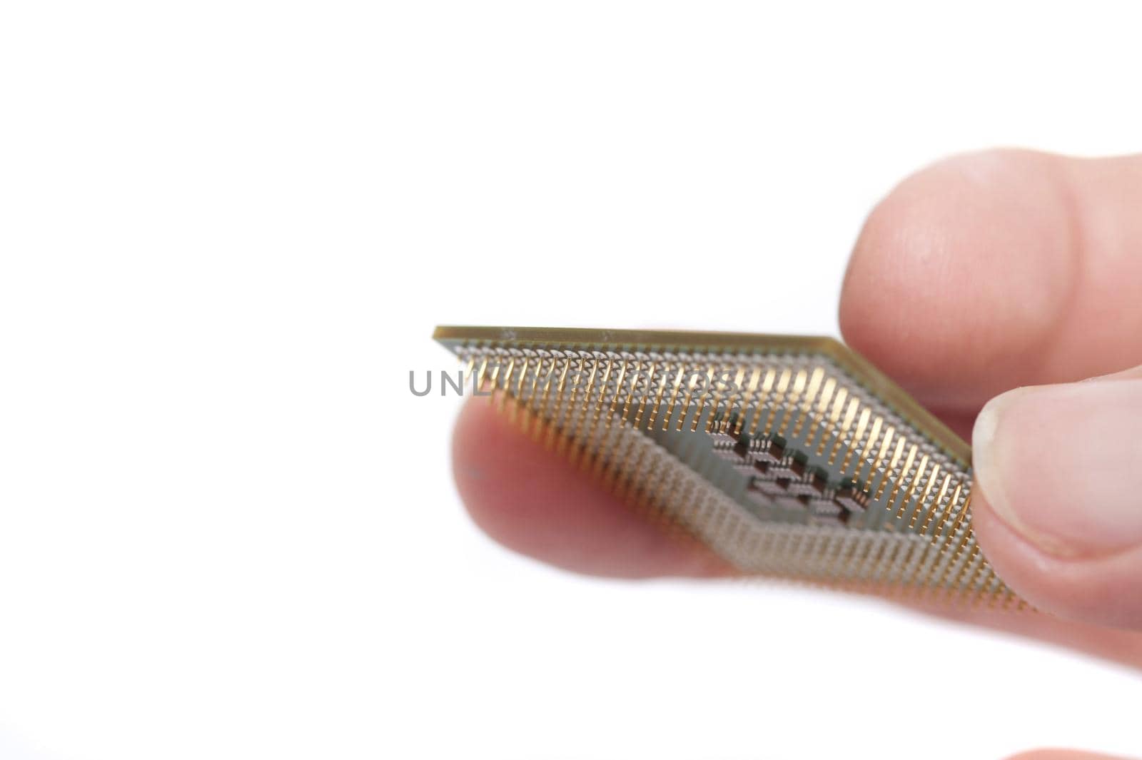 Fingers holding cpu computer processor chip with pins shown