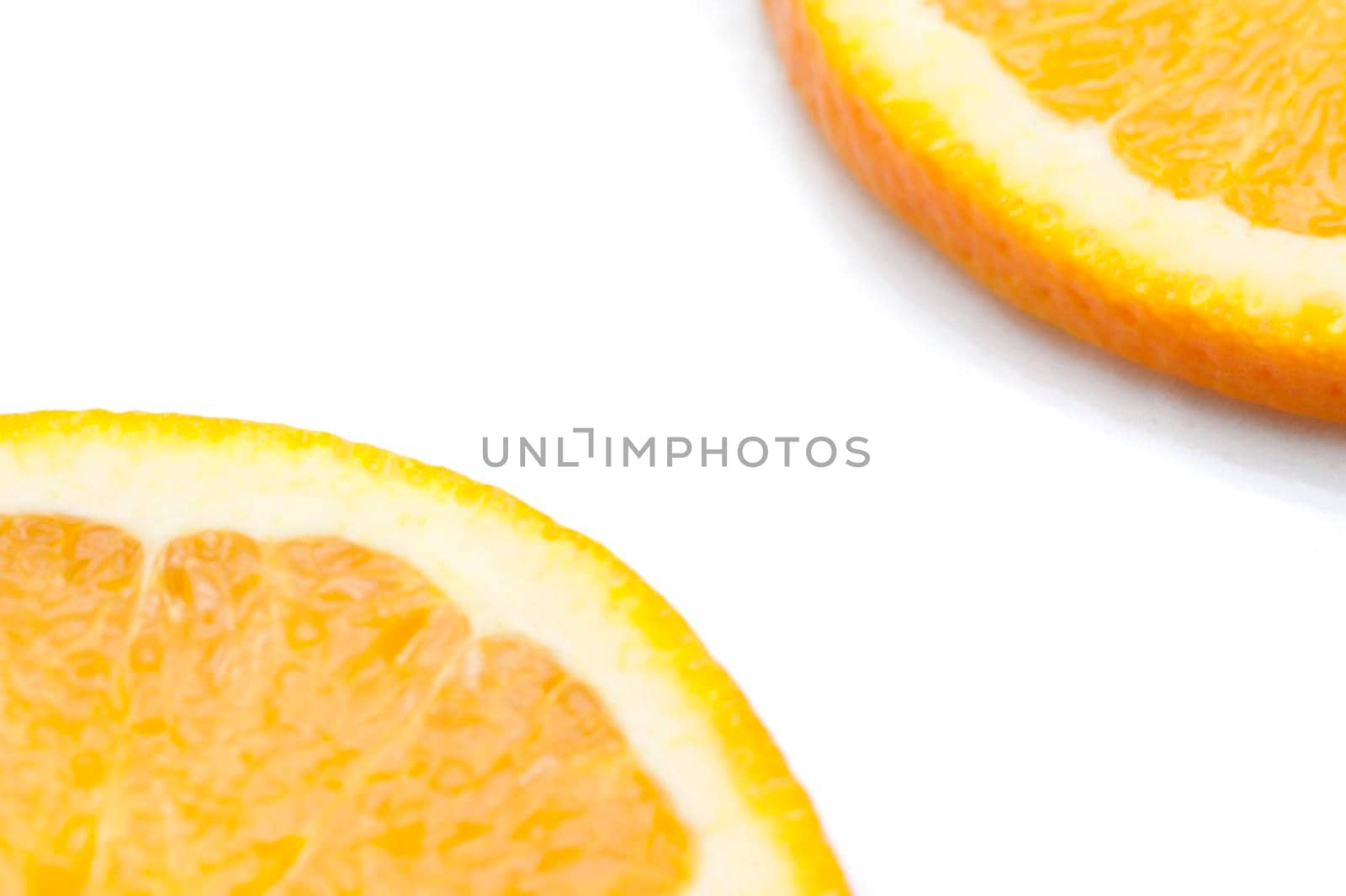 Partial view on a white background with copyspace between them of slices of fresh juicy orange citrus fruit showing the texture of the pulp