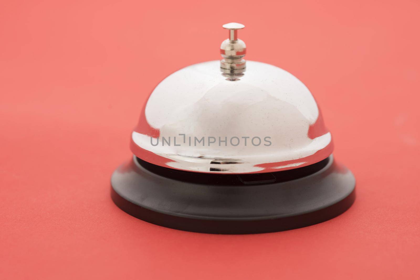 Close-up of reception bell standing against red background